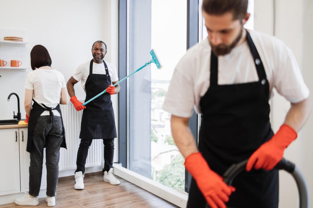 focus on positive african american worker cleaning panoramic window.