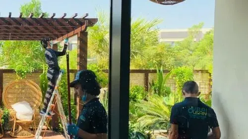 Professional balcony cleaning services in Dubai with cleaner using specialized equipment on high-rise apartment balcony