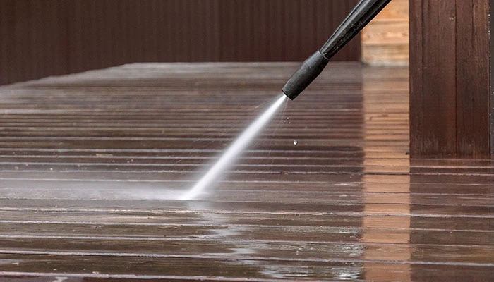 Power wash cleaning in progress on a driveway with high-pressure water