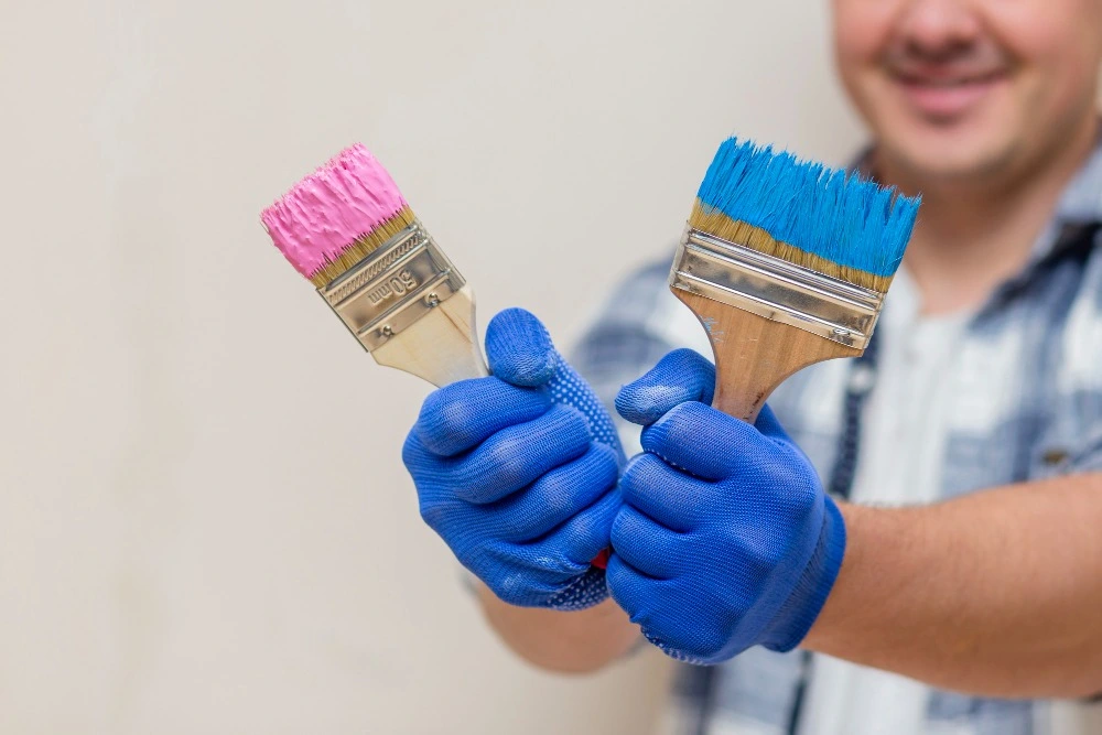 Our expert painter holding brushes, ready to paint your home.