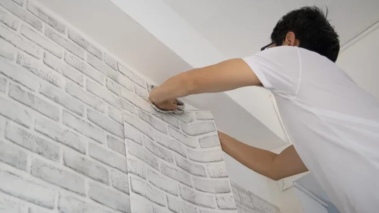 Expert wallpaper fixing Dubai service showing precise installation of beautiful wallpaper patterns