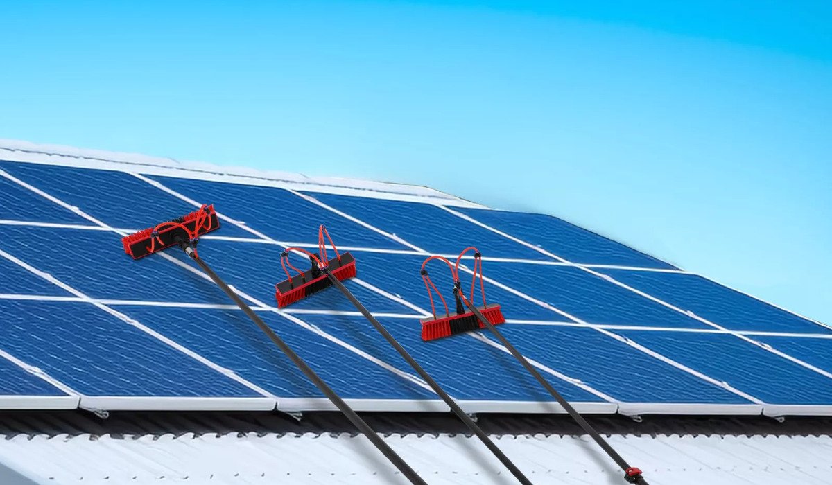 Technician performing solar panel cleaning on a rooftop using professional tools