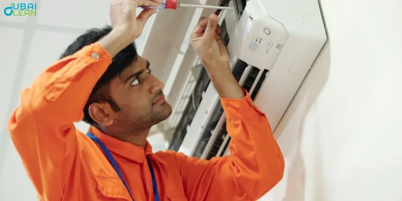 Technician performing AC duct installation and maintenance work in Dubai residential building showing proper ventilation system setup.