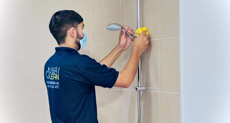 Professional doing move-in/out deep cleaning behind kitchen appliances in Dubai